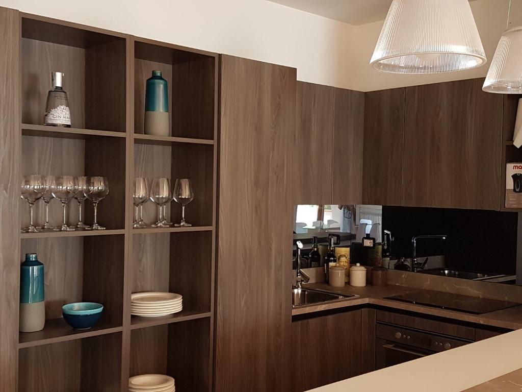 a kitchen with wooden shelves with glasses and a sink at Villa Crawford in San Nicola Arcella