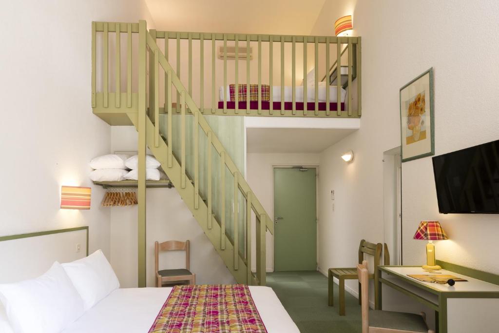 une chambre d'hôtel avec un lit et un escalier dans l'établissement Logis Hôtel Restaurant Les Cèdres, à Joyeuse