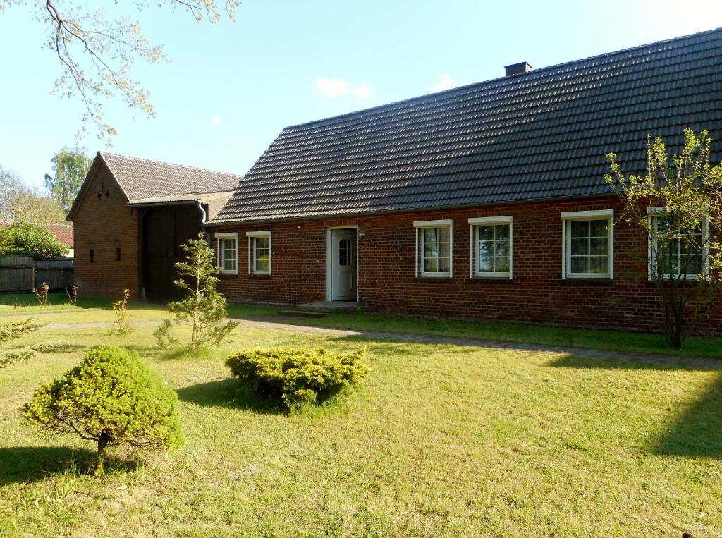 a red brick house with a yard in front of it at Ferienwohnung Hille in Arendsee