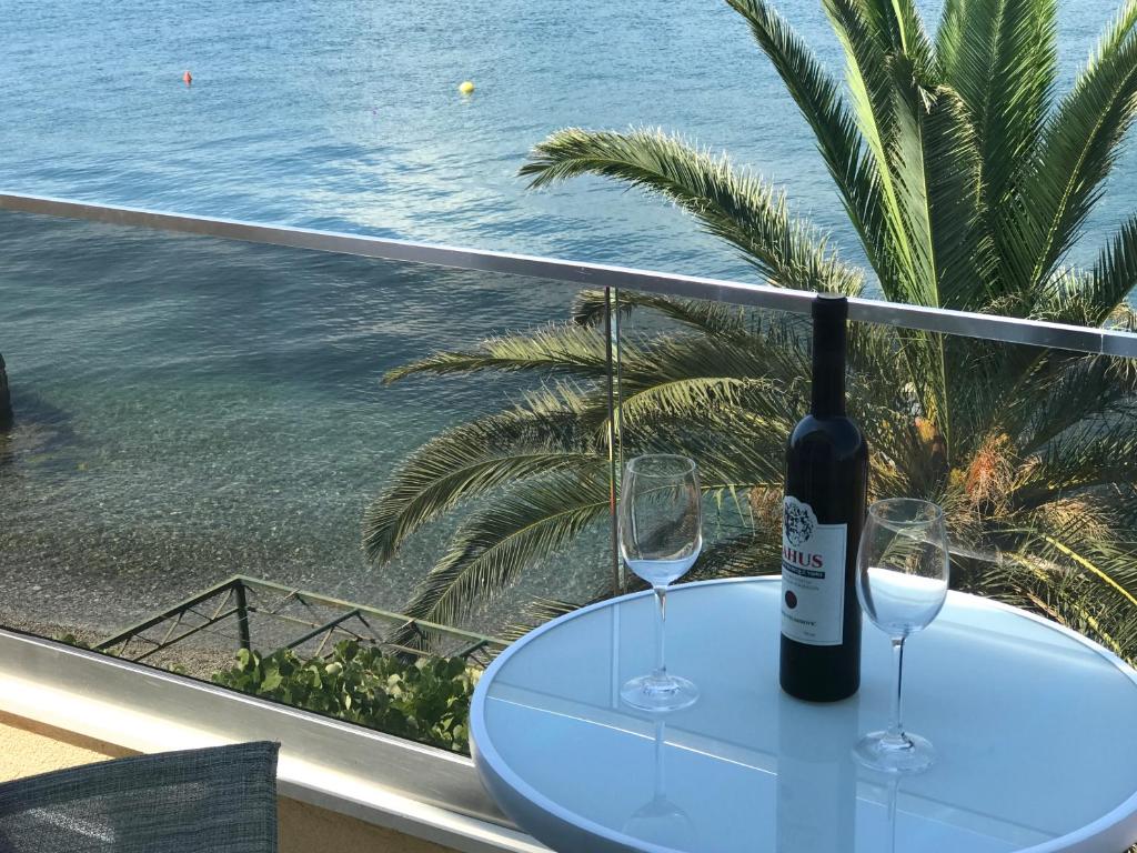 a table with two glasses and a bottle of wine at Franovic Apartments in Tivat