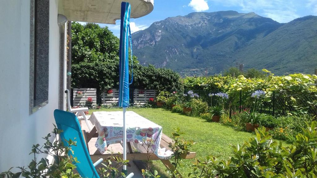 a table and chairs in a yard with a mountain at Apartment Viola in Arco