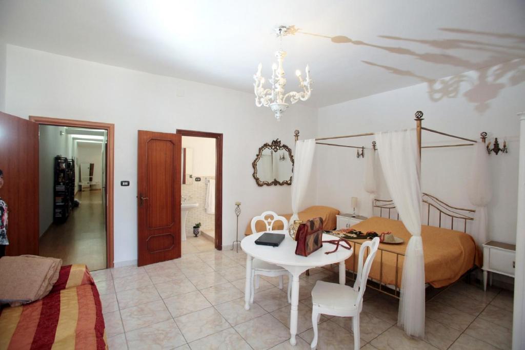 - une chambre avec un lit, une table et des chaises dans l'établissement ZO. NE. Baroque B&B, à Lecce