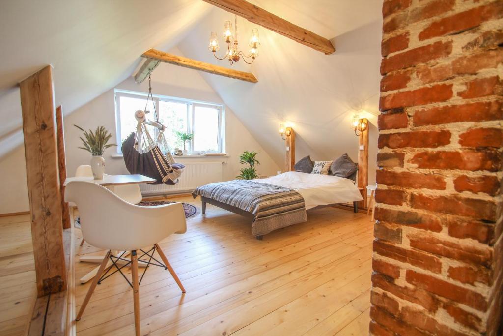 a bedroom with a bed and a table and a chair at Ligatne Homestay in Līgatne