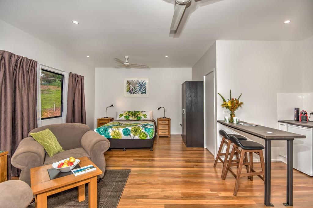 a living room with a bed and a table and a couch at Eumundi Cottages - Cottage 1 in Eumundi