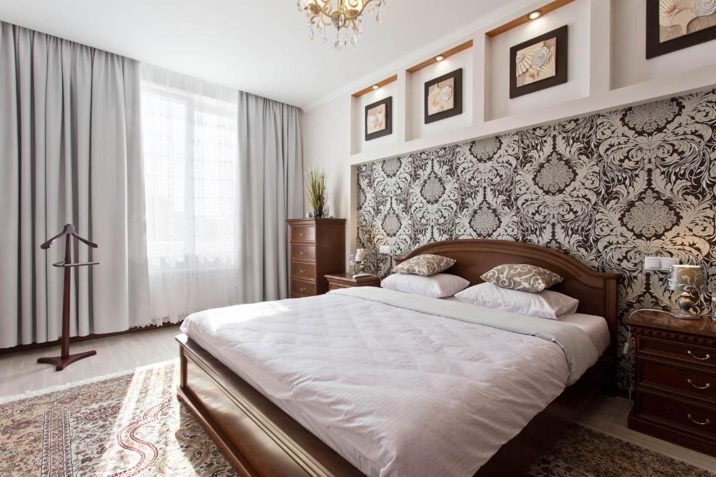 a bedroom with a large bed and a wall at Cozy Apartments in Arcadia in Odesa