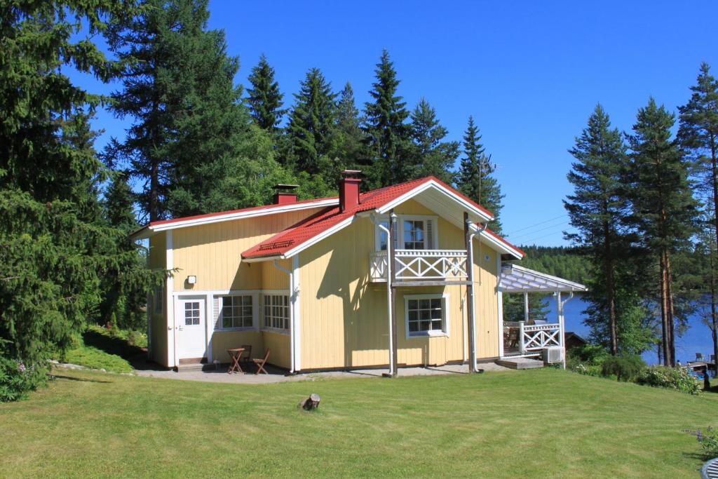ein gelbes Haus mit rotem Dach auf einem Hof in der Unterkunft Keitaanniemen lomamökki in Haapamäki