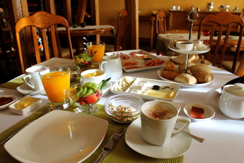 a table with breakfast foods and drinks on it at Hotel Boutique Acontraluz in Valparaíso
