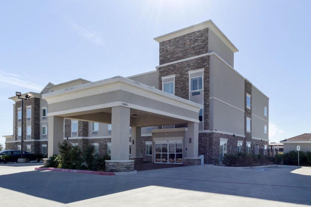 a large building with a parking lot in front of it at Quality Inn & Suites Victoria East in Victoria
