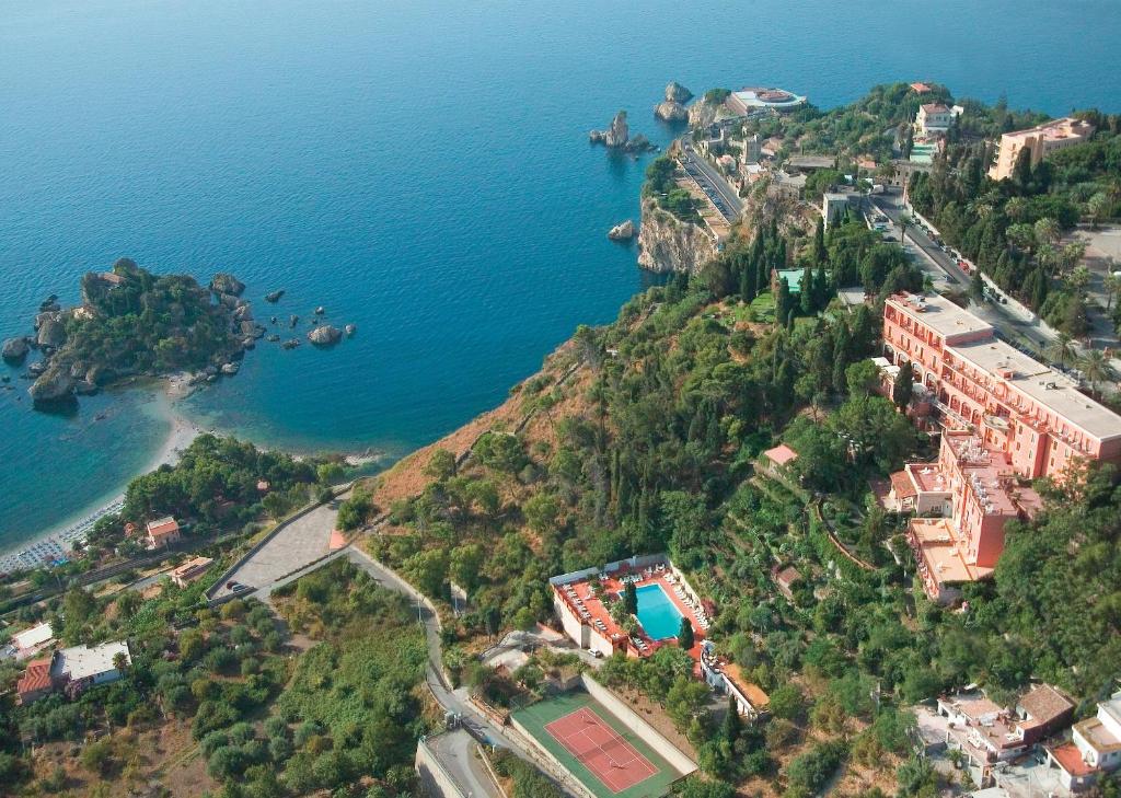 una vista aerea di un resort su una collina vicino all'oceano di Grand Hotel Miramare a Taormina
