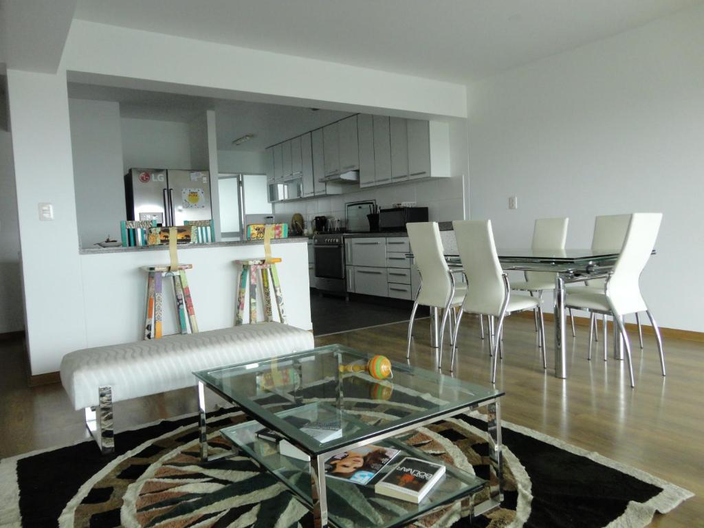 a living room with a table and chairs and a kitchen at San Borja, bello apartamento in Lima