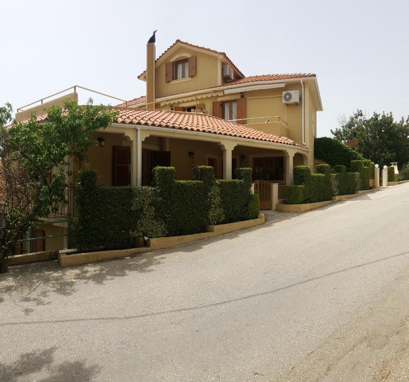 ein Haus mit Hecken am Straßenrand in der Unterkunft Epi Apartments in Lourdata