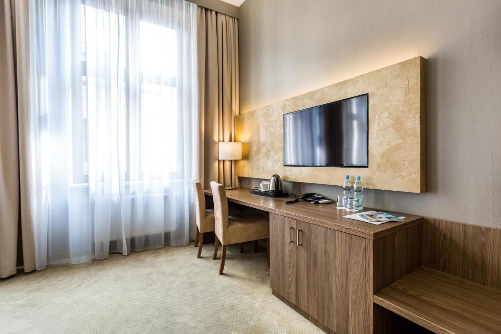 a hotel room with a desk and a television at Hotel Elektor Premium in Kraków