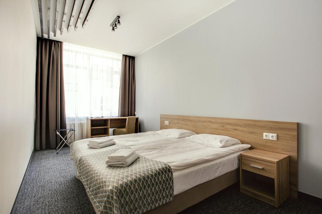 sypialnia z dużym łóżkiem i oknem w obiekcie Old Town Trio Hostel Rooms w Wilnie