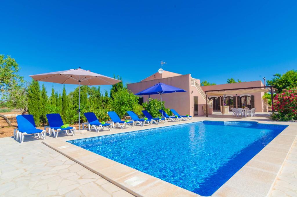 a swimming pool with blue chairs and umbrellas at Finca Rustica Arcos in Campos