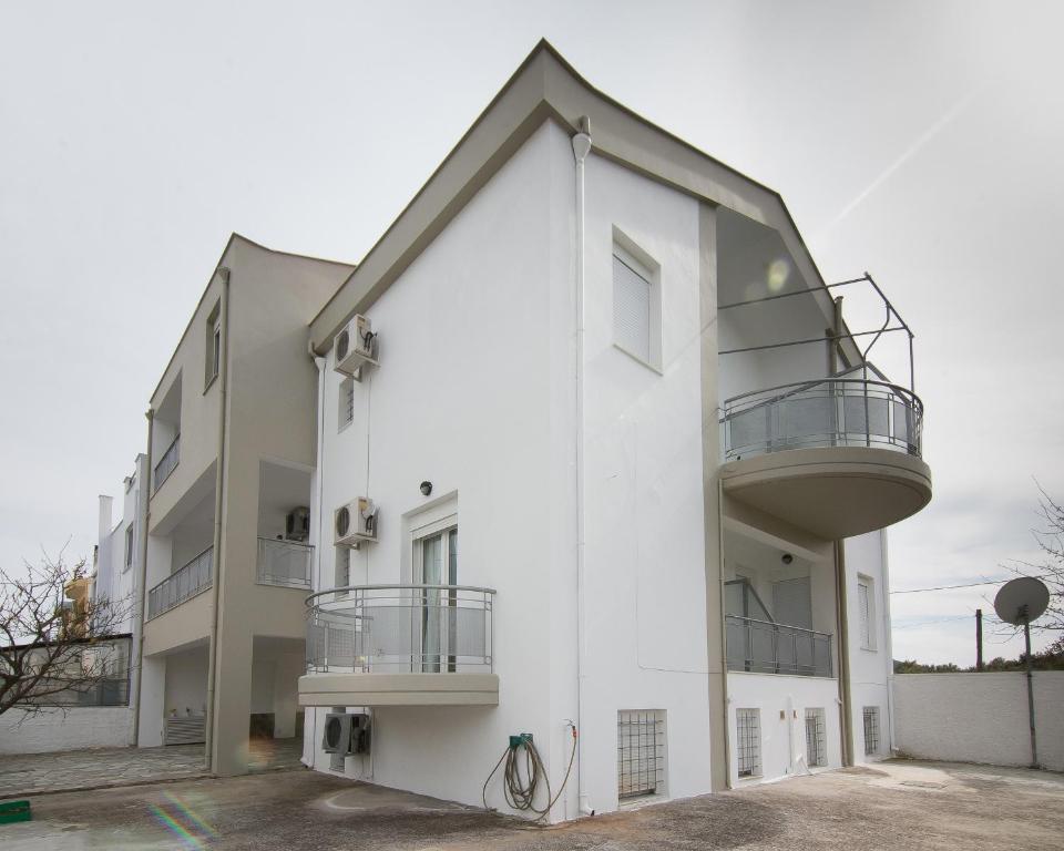 ヴォロスにあるCoastal Apartments Volos Alykesの白い建物(横にバルコニー付)