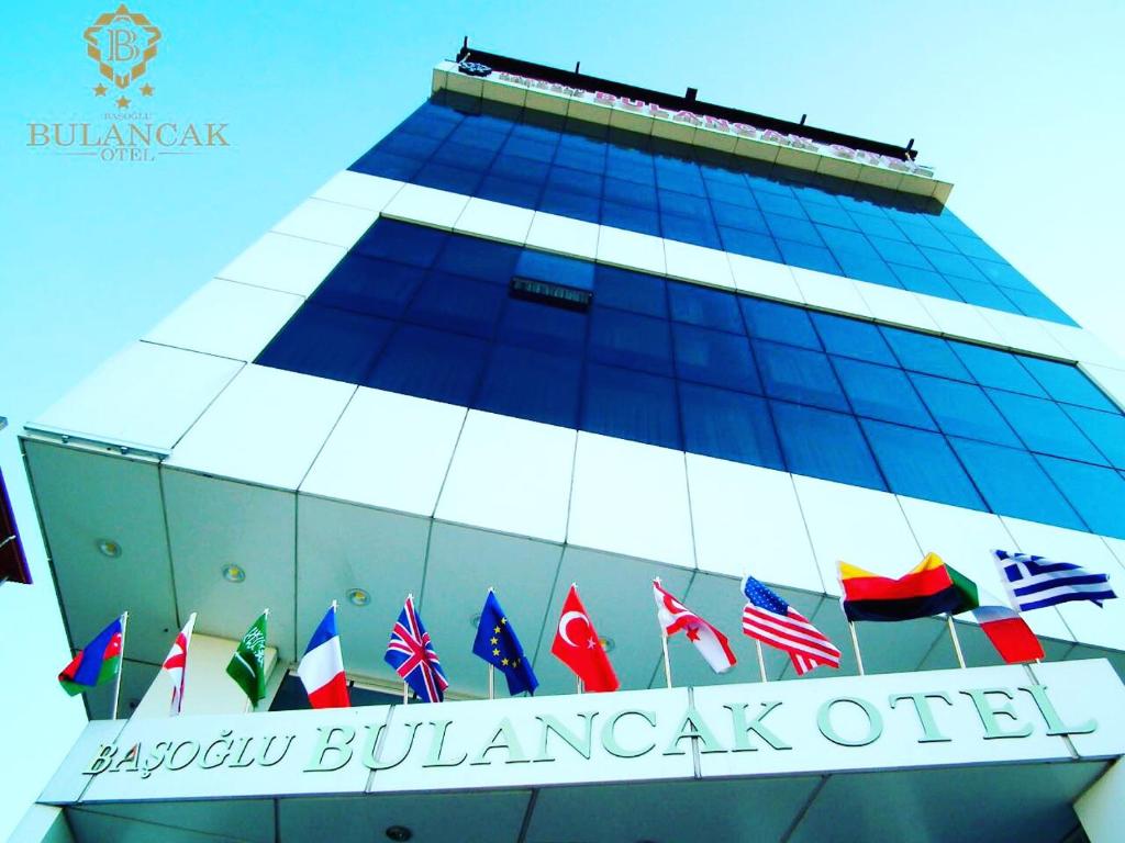 a building with a bunch of flags on it at Basoglu Bulancak Hotel in Bulancak