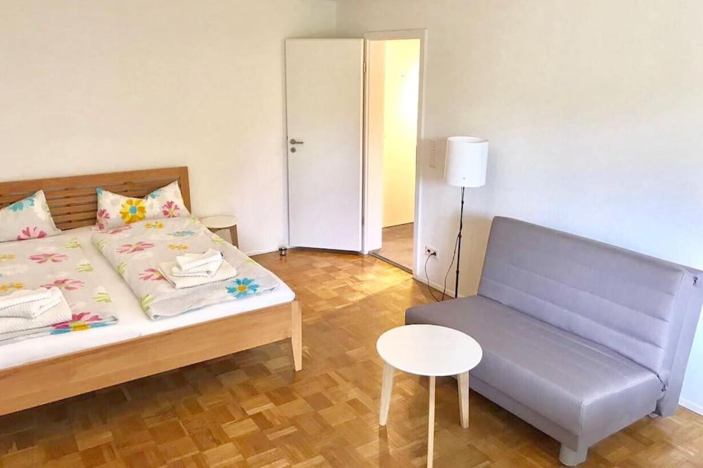 ein Schlafzimmer mit einem Bett, einem Stuhl und einem Tisch in der Unterkunft FeWo "Im Birnaublick" in Konstanz