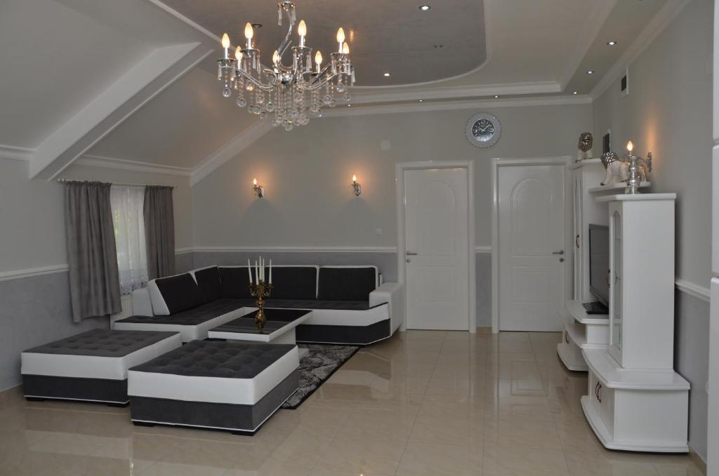 a living room with a couch and a chandelier at Apartments Royal Menex in Požarevac
