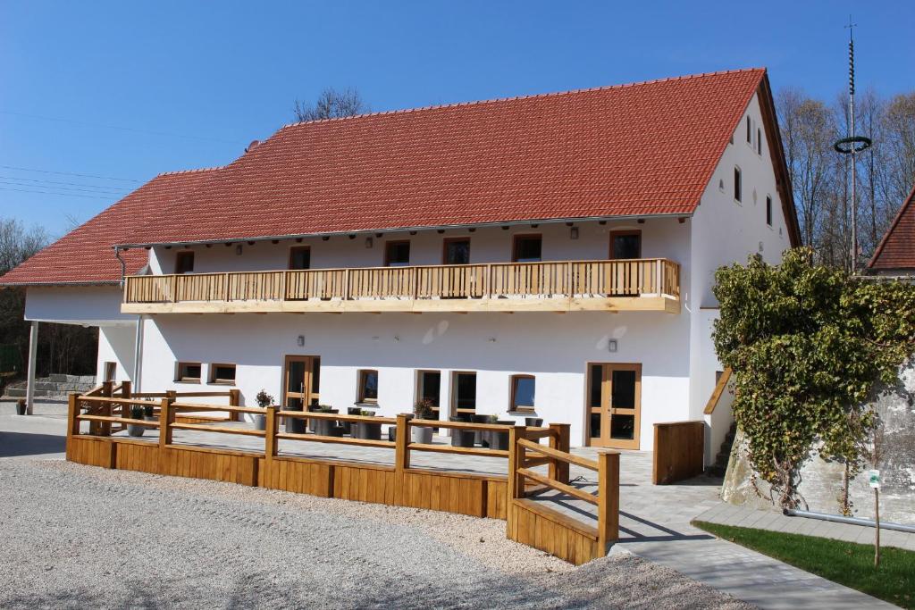 a large white house with a wooden fence at SPIEGLHOF apart in Kumhausen