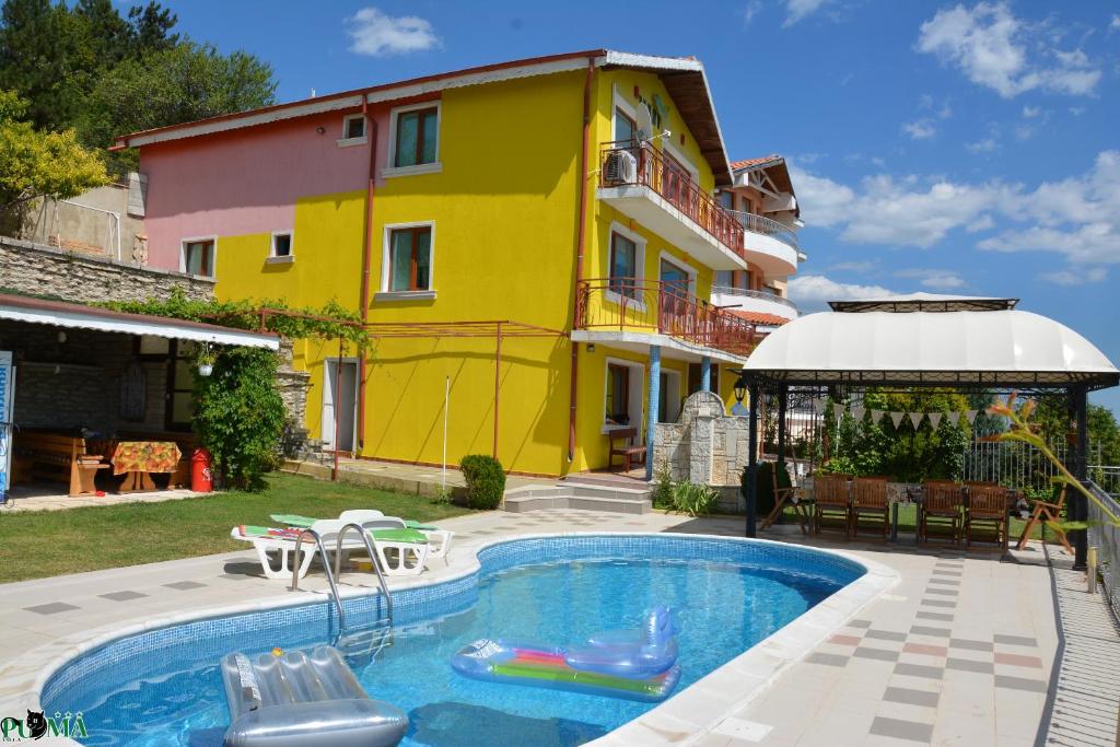 a villa with a swimming pool in front of a house at Villa Puma in Balchik