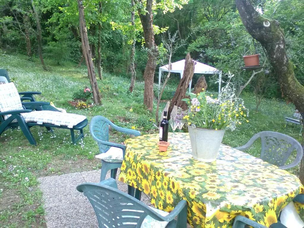 サン・カシャーノ・イン・ヴァル・ディ・ペーザにあるPodere Taraのワイン1本と花のテーブル
