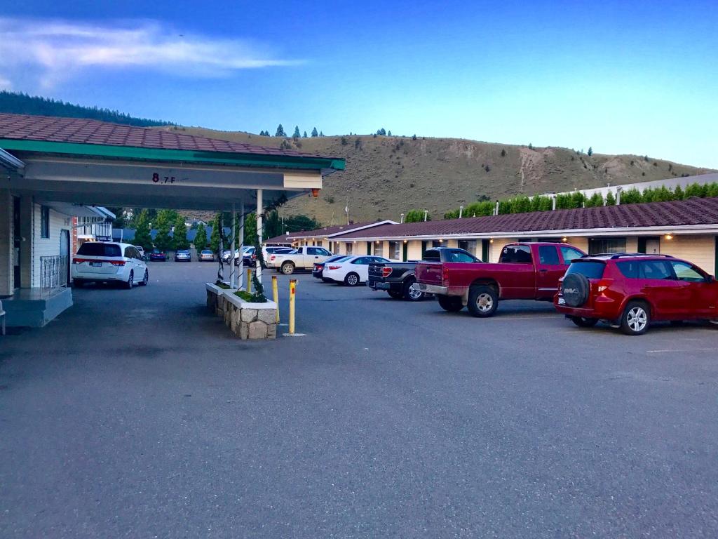 un estacionamiento con autos estacionados frente a un edificio en Trans Canada Motel en Kamloops