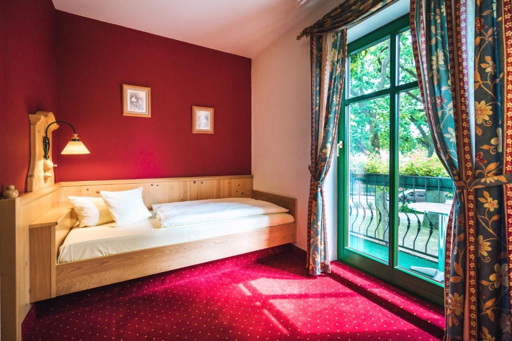 a bedroom with a bed and a window at Landgasthof zum Mühlenteich in Eggersdorf