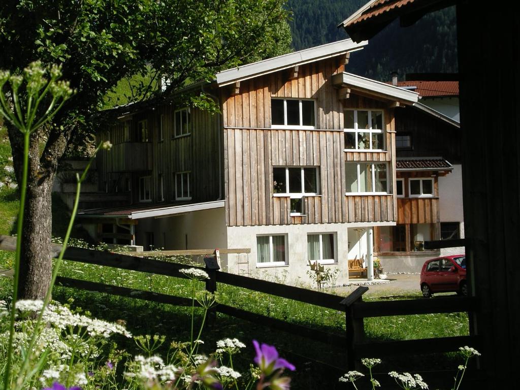 a wooden house with a fence in front of it at Nadlihof in Flirsch