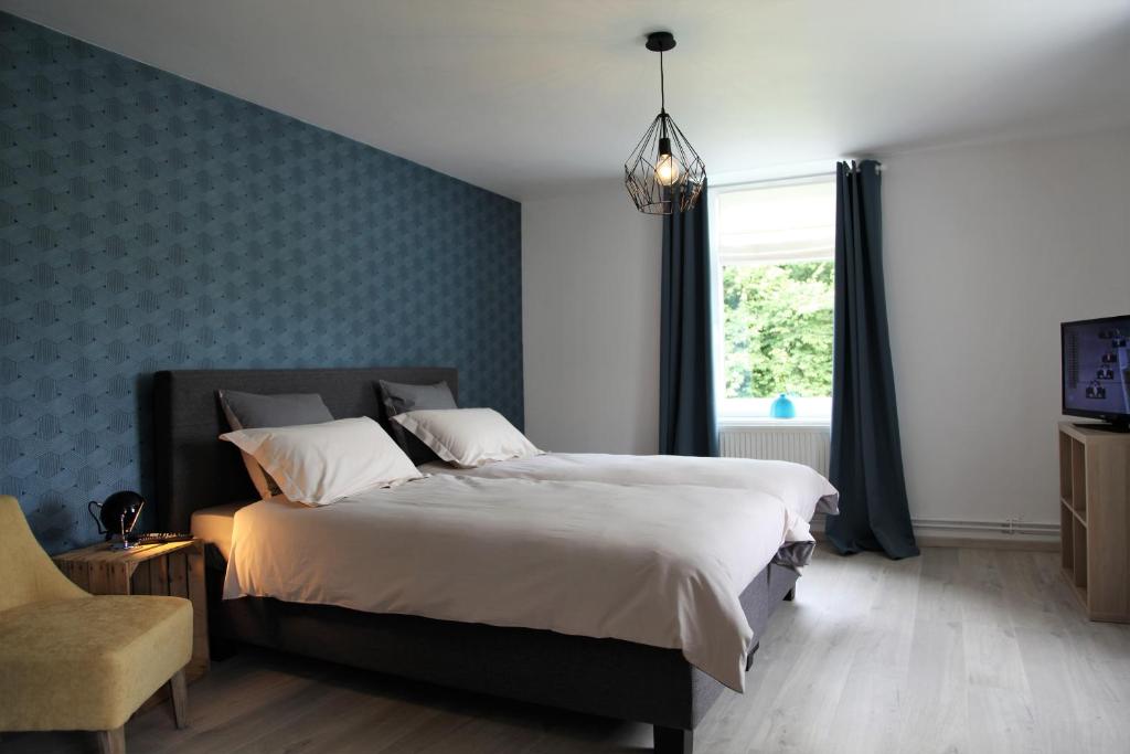 a bedroom with a large bed and a window at Les Lucioles in Francorchamps