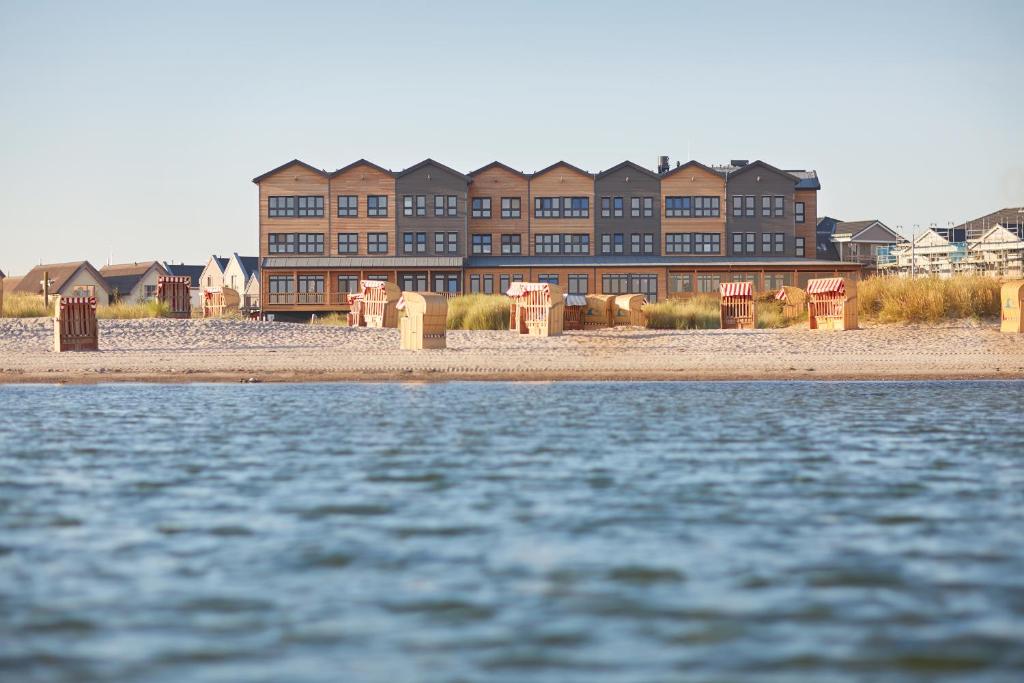 ein großes Gebäude vor einem Wasserkörper in der Unterkunft Bretterbude Heiligenhafen in Heiligenhafen