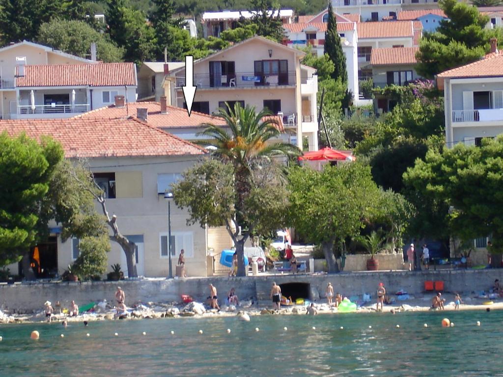 un groupe de personnes sur une plage dans l'eau dans l'établissement Apartmani Ivana & Toni, à Gradac