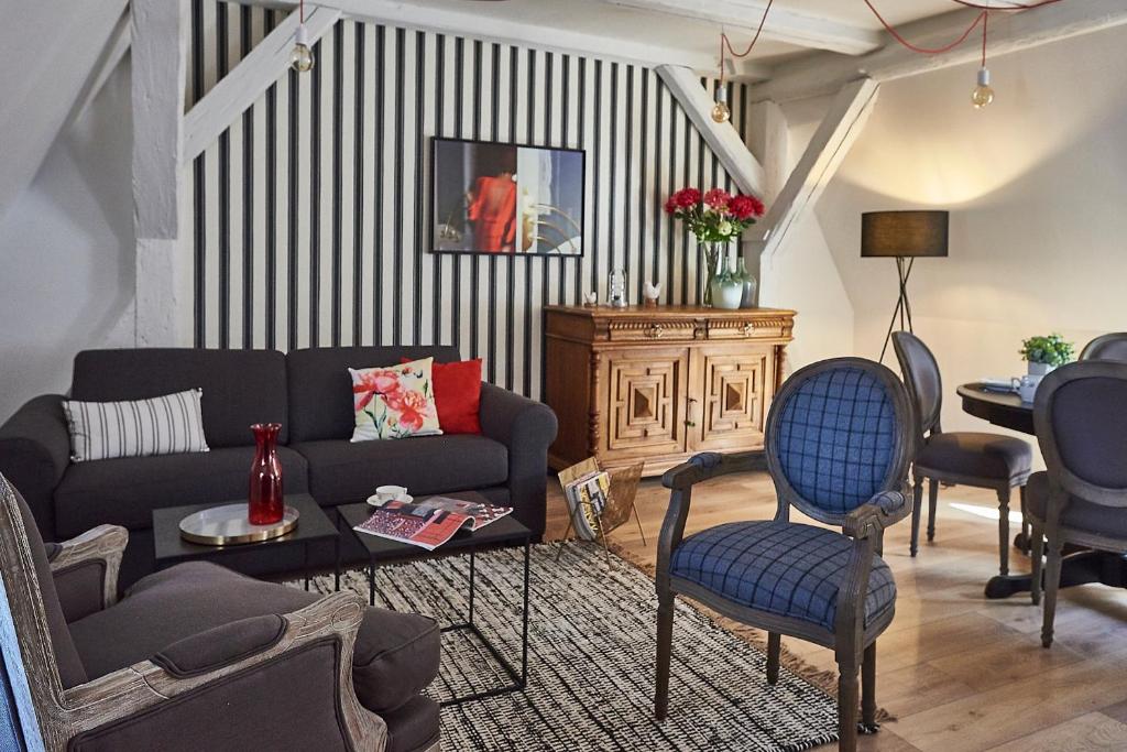 Les Appartements Saint-Martin في كولمار: غرفة معيشة مع أريكة وطاولة