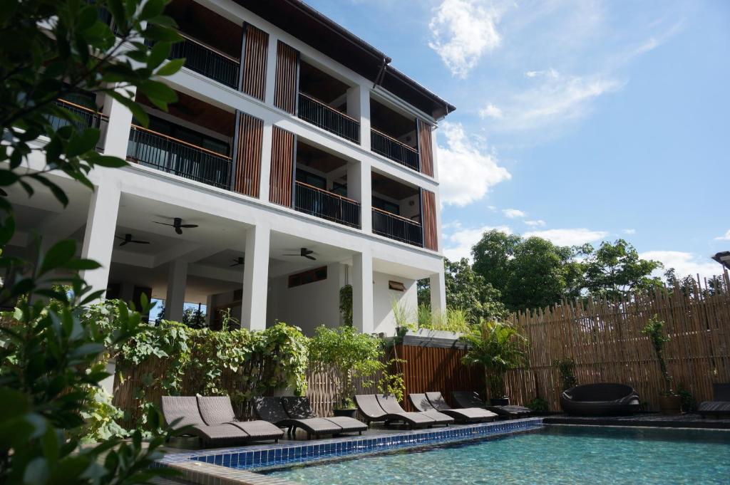 een huis met een zwembad naast een gebouw bij SugarCane Chiang Mai in Chiang Mai