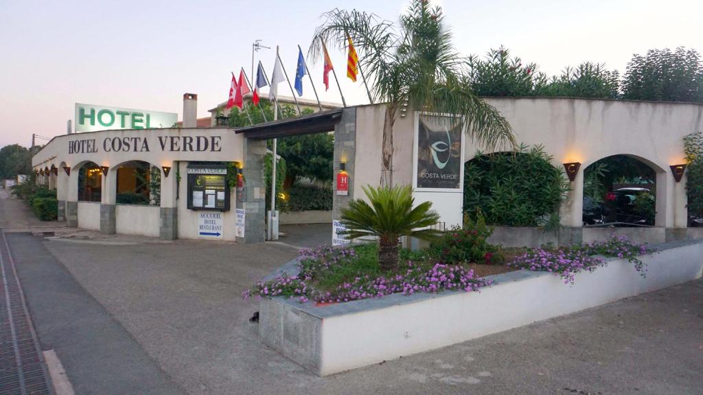 a hotel with flowers in front of a building at Hotel Costa Verde in Moriani Plage