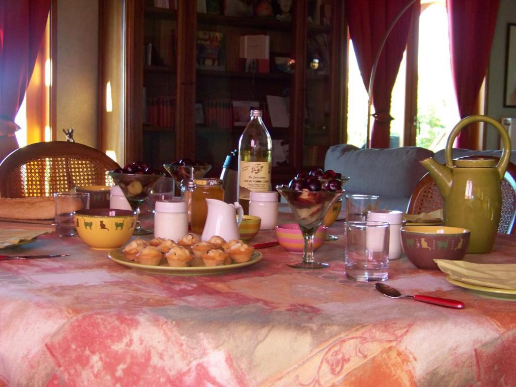 una mesa con un plato de comida y una botella de vino en Croix Blanche, en Cellieu