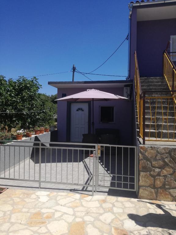 a fence in front of a house with a porch at Apartment Marko in Šibenik