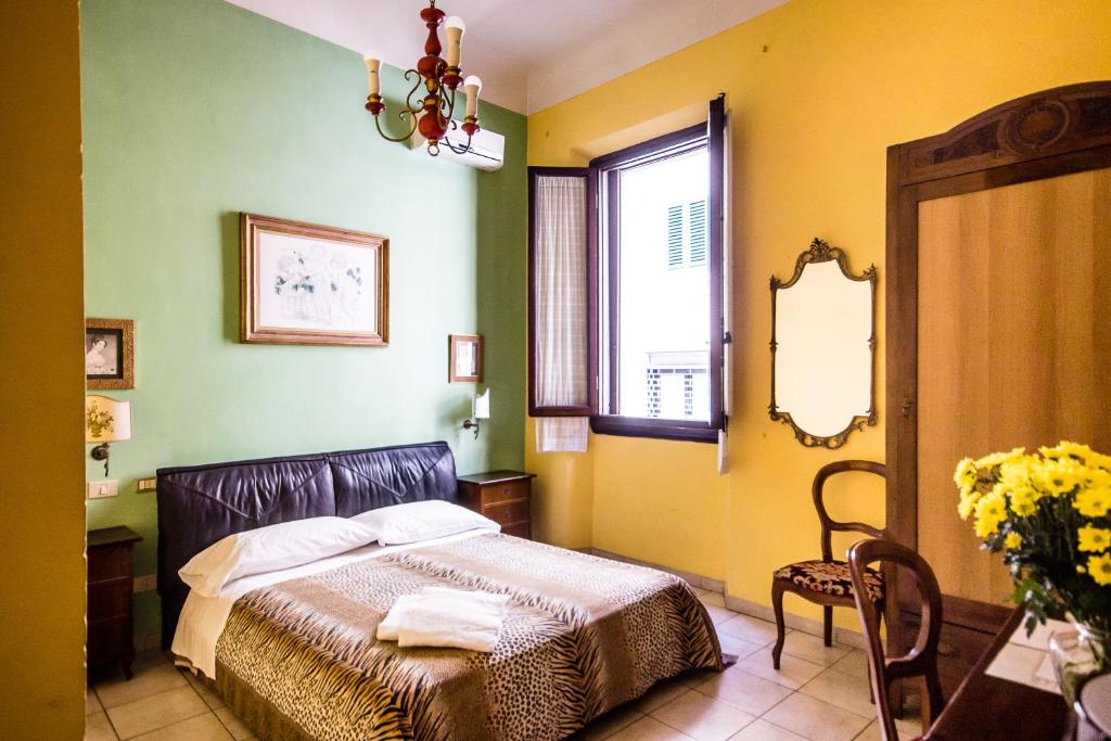 sypialnia z łóżkiem, oknem i lustrem w obiekcie Hotel Il Bargellino we Florencji