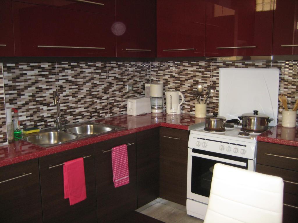 ハニア・タウンにあるApartment with a small loft and modern kitchenのキッチン(ブラウンキャビネット、コンロ、シンク付)