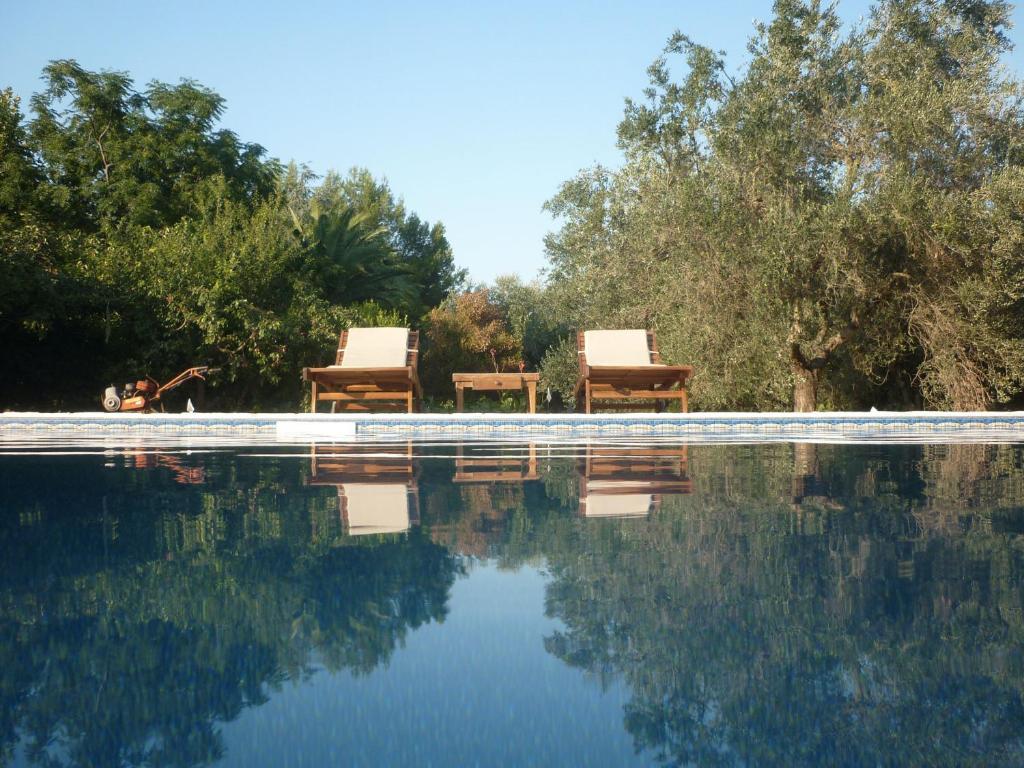 duas cadeiras sentadas ao lado de uma piscina em B&B Villa Giuliana em Arnesano
