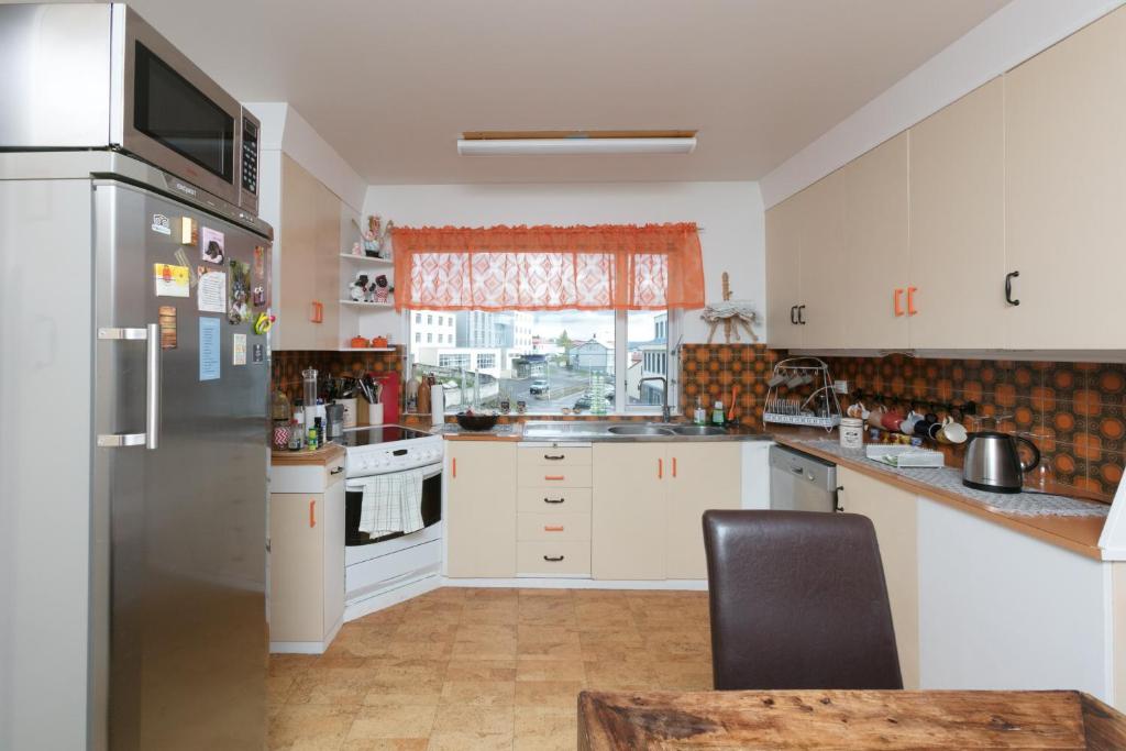 cocina con nevera de acero inoxidable y ventana en Blómasetrið Homestay, en Borgarnes