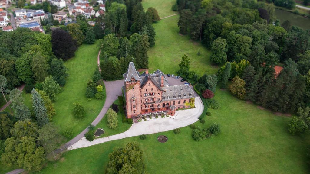 an aerial view of a large house on a green field at Gästehaus Schloss Saareck in Mettlach