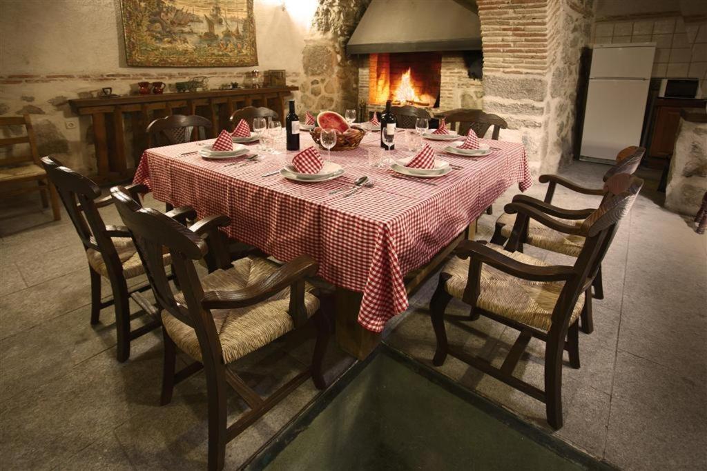 mesa de comedor con mantel rojo y blanco en Casa Rural La Bodega en Sonseca