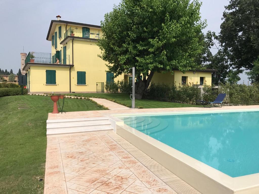 a house with a swimming pool in front of a house at Albergo Quattro Pini in Pozzolengo