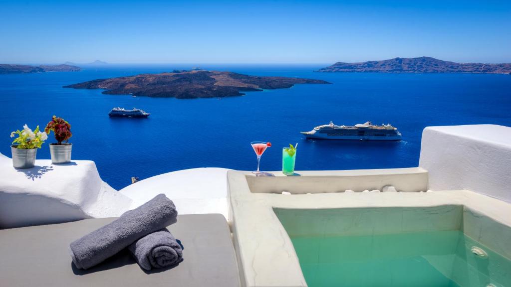 a balcony with a view of the ocean and boats at Modernity Suites in Fira