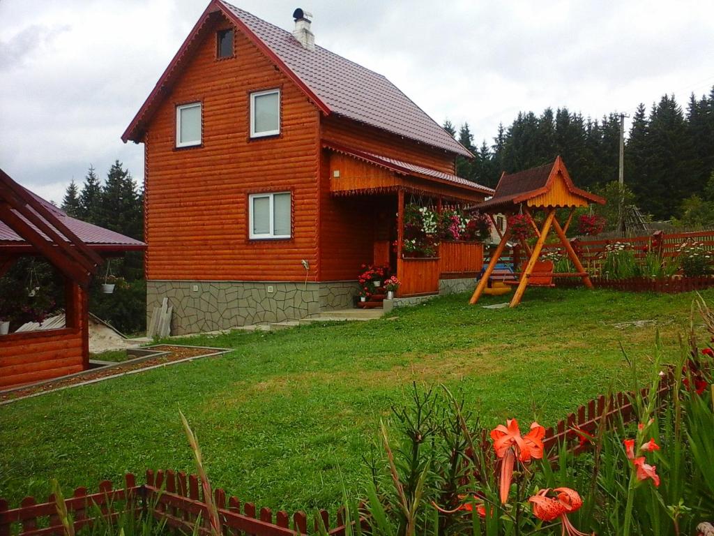 Casa de madera con cenador en un patio en Romashka Guest House, en Yablunytsya