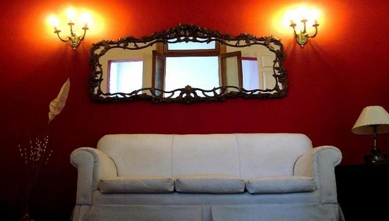 a living room with a white couch and a mirror at Hostel Point in Rosario