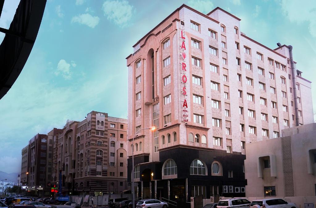 różowy budynek z napisem na boku w obiekcie La Rosa Hotel Oman w Maskacie