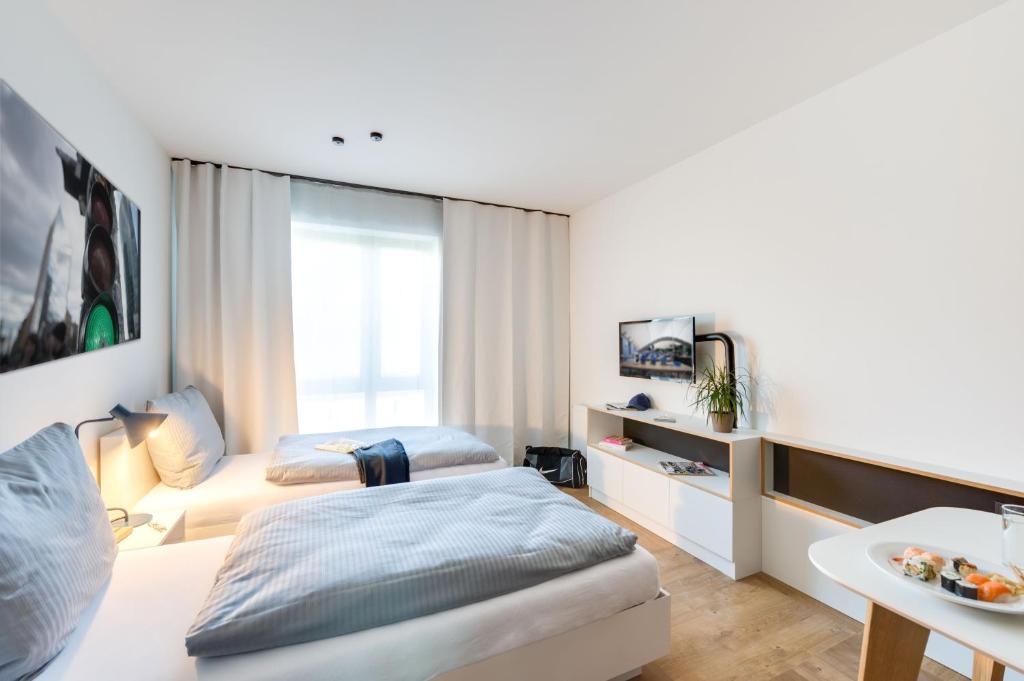 ein Hotelzimmer mit einem Bett und einem Sofa in der Unterkunft SMARTments business Berlin Karlshorst in Berlin