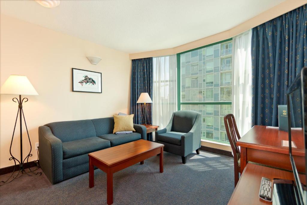 a living room with a couch and a chair at Rosedale on Robson Suite Hotel in Vancouver
