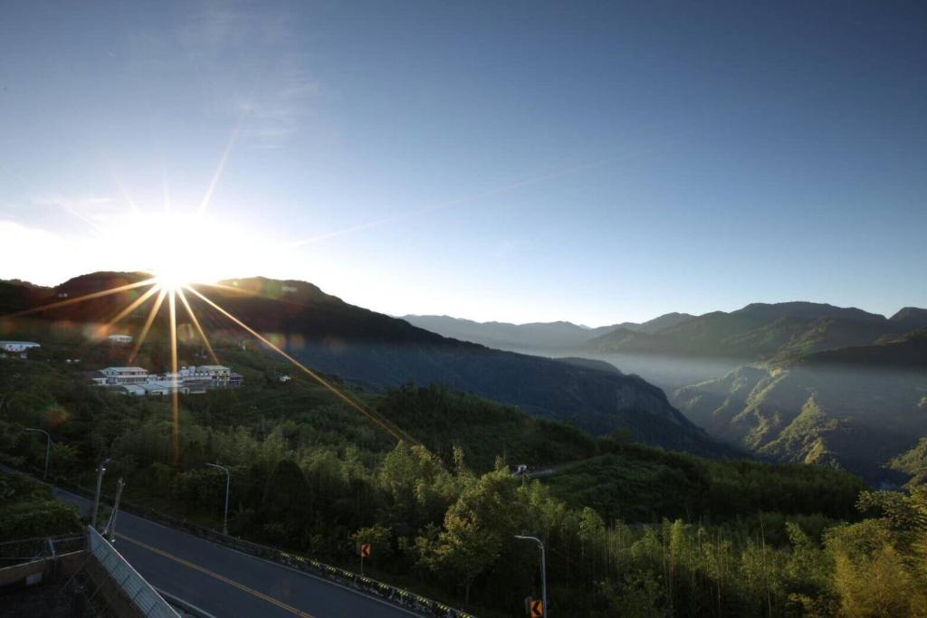 a view of the sun rising over a mountain with a road at Tea Cloud B&amp;B in Leye